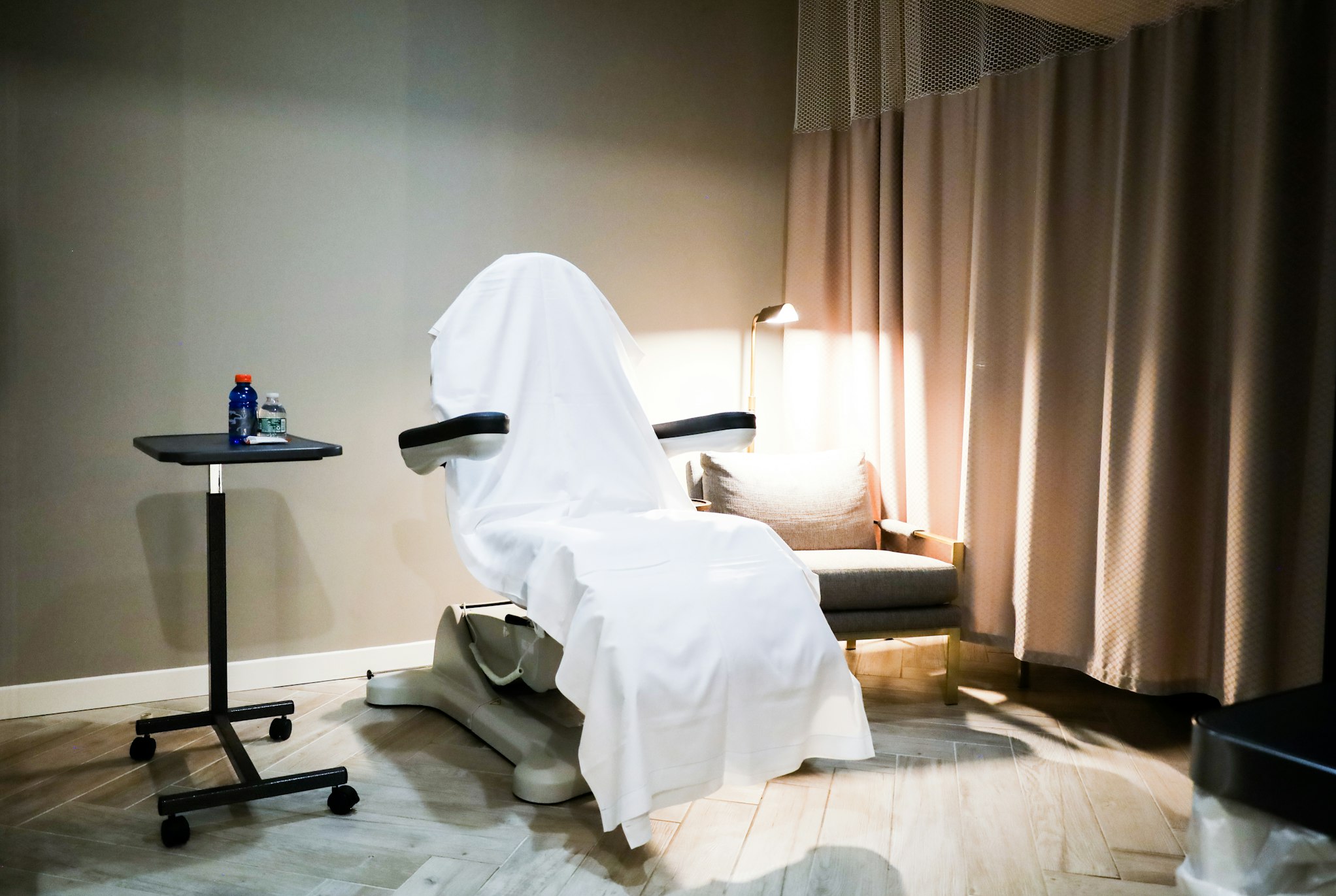 Recovery room with covered medical chair and curtain in AirSculpt Body Contouring Sacramento clinic