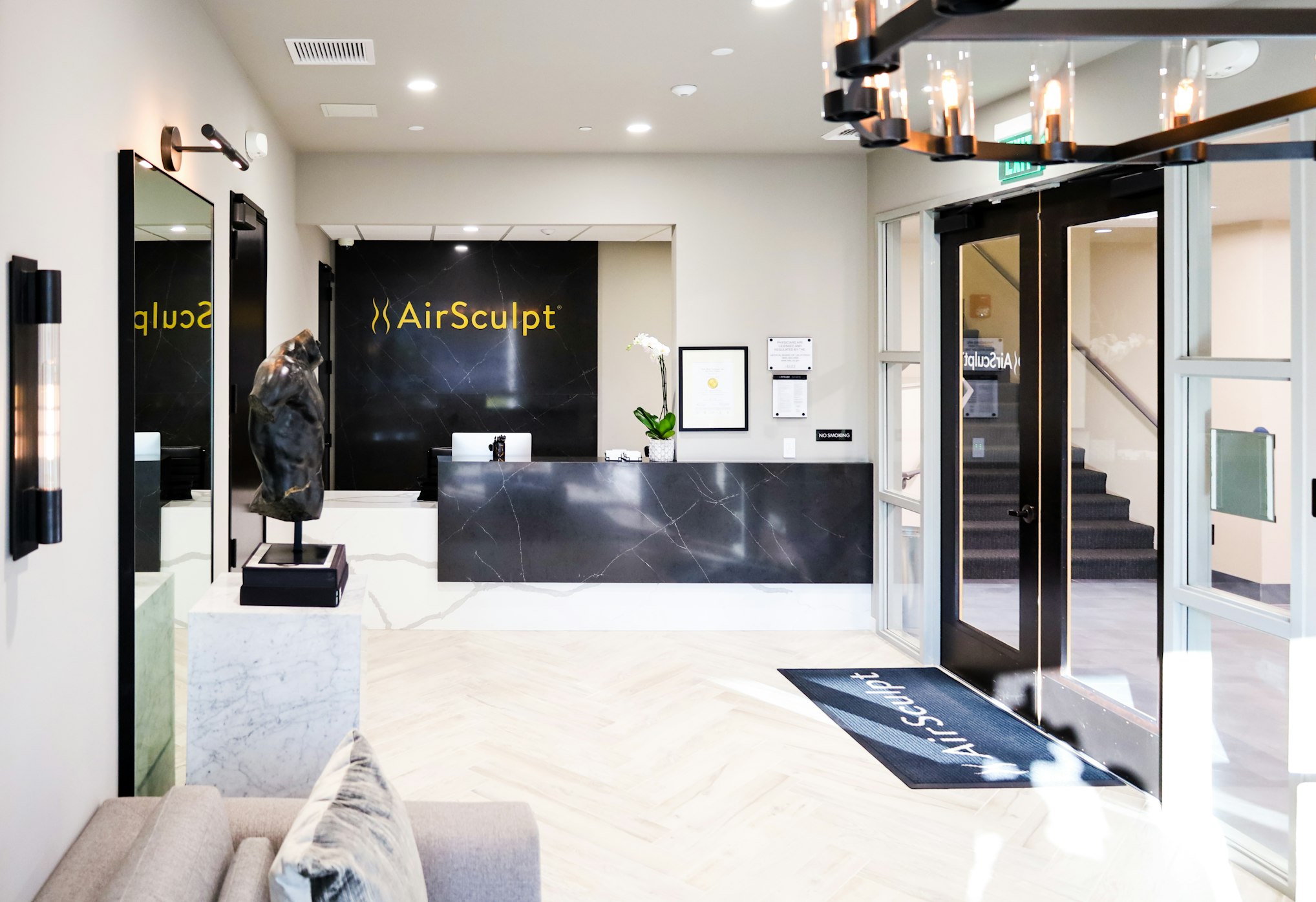 Front desk and backdrop featuring AirSculpt logo in AirSculpt Body Contouring Sacramento clinic lobby