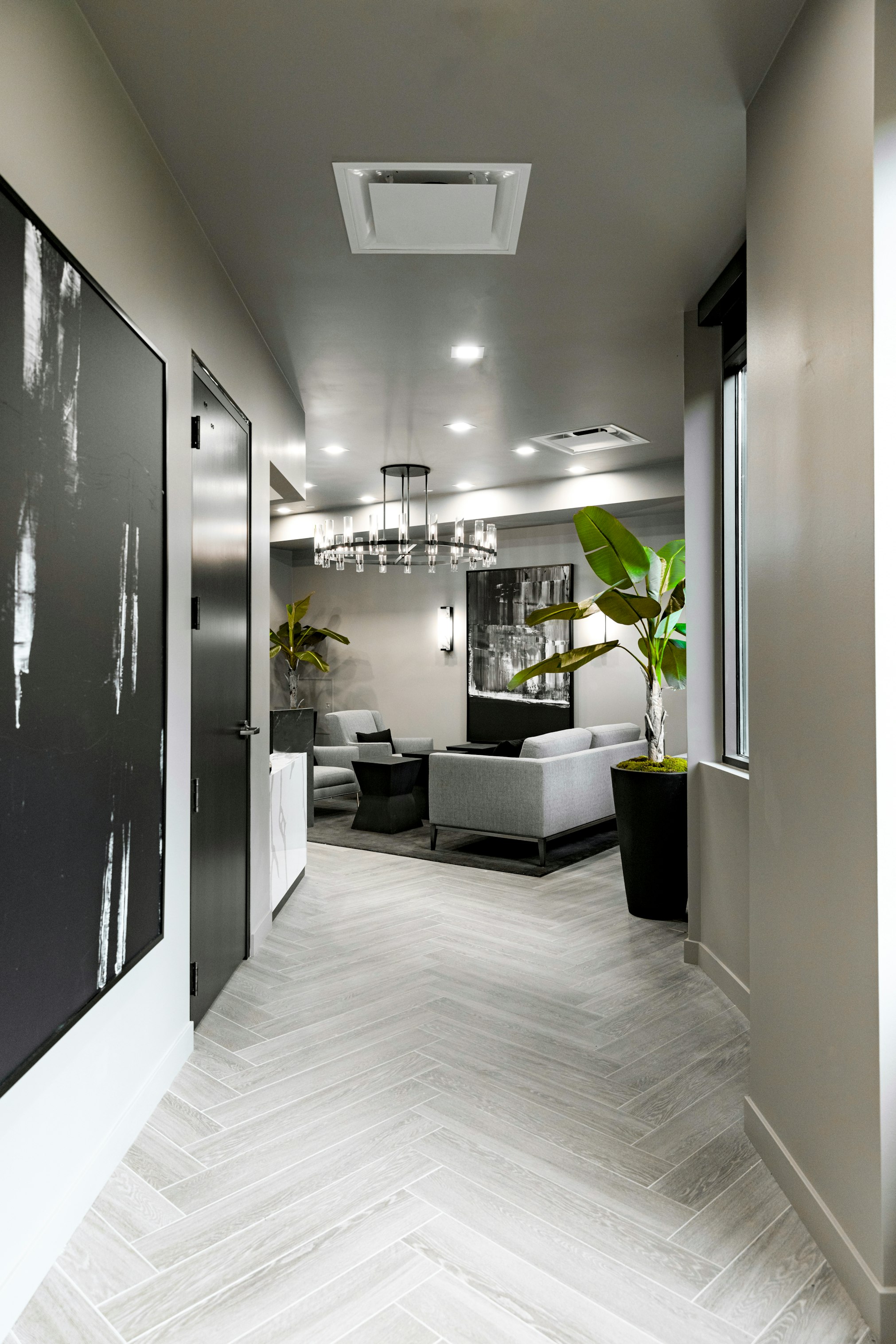 Lobby seating area and hallway entrance with potted plants in AirSculpt Body Contouring Salt Lake City clinic