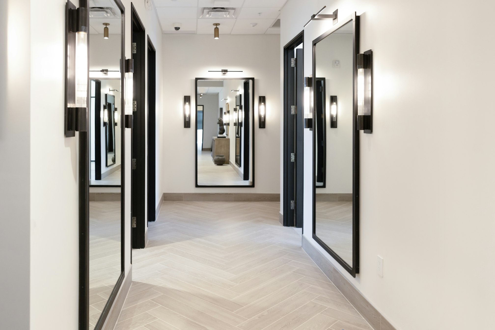 Hallway with mirrored panels and wall sconces in AirSculpt Body Contouring Scottsdale clinic