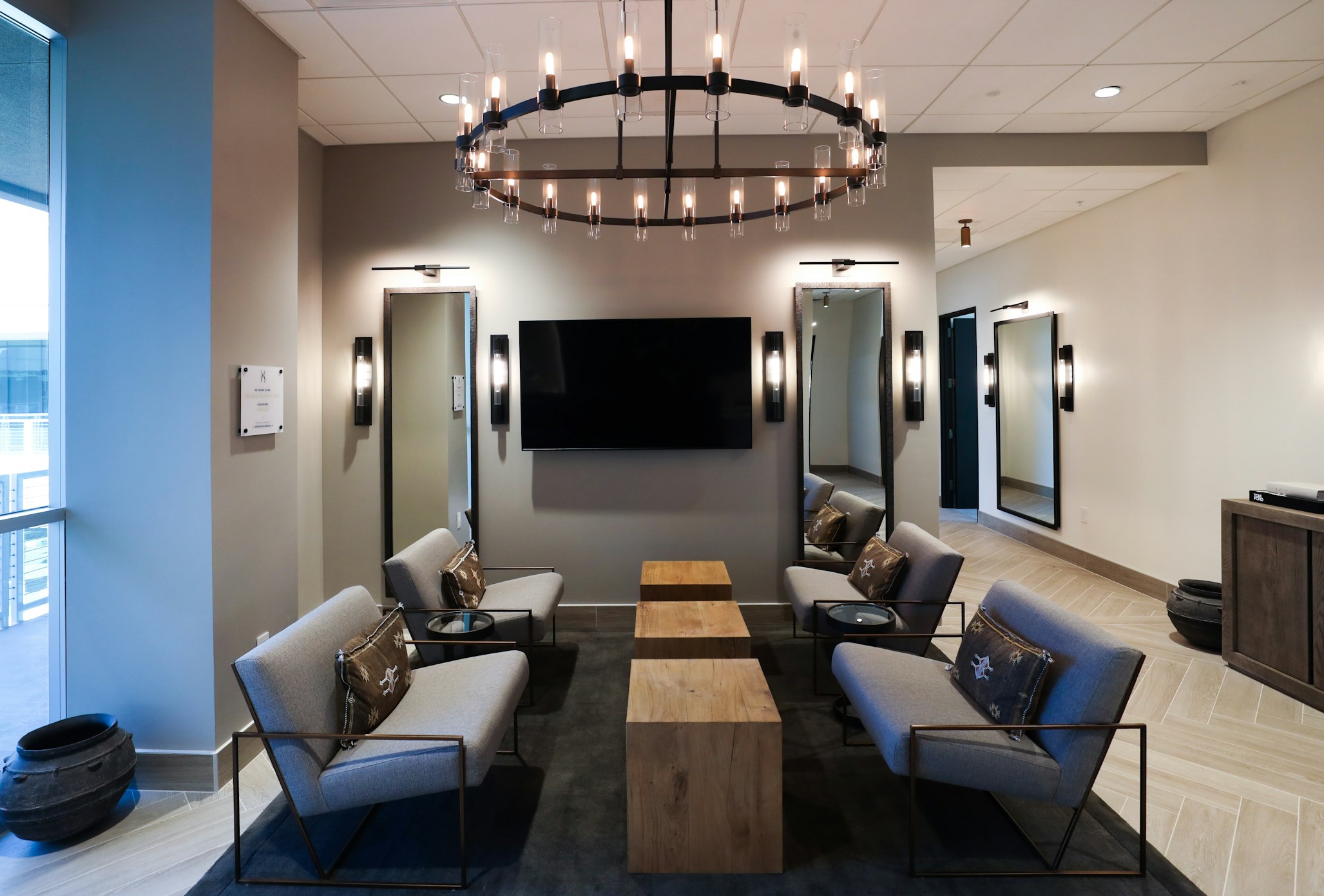 Lobby seating area with couch, coffee tables, and chandelier in AirSculpt Body Contouring Scottsdale clinic