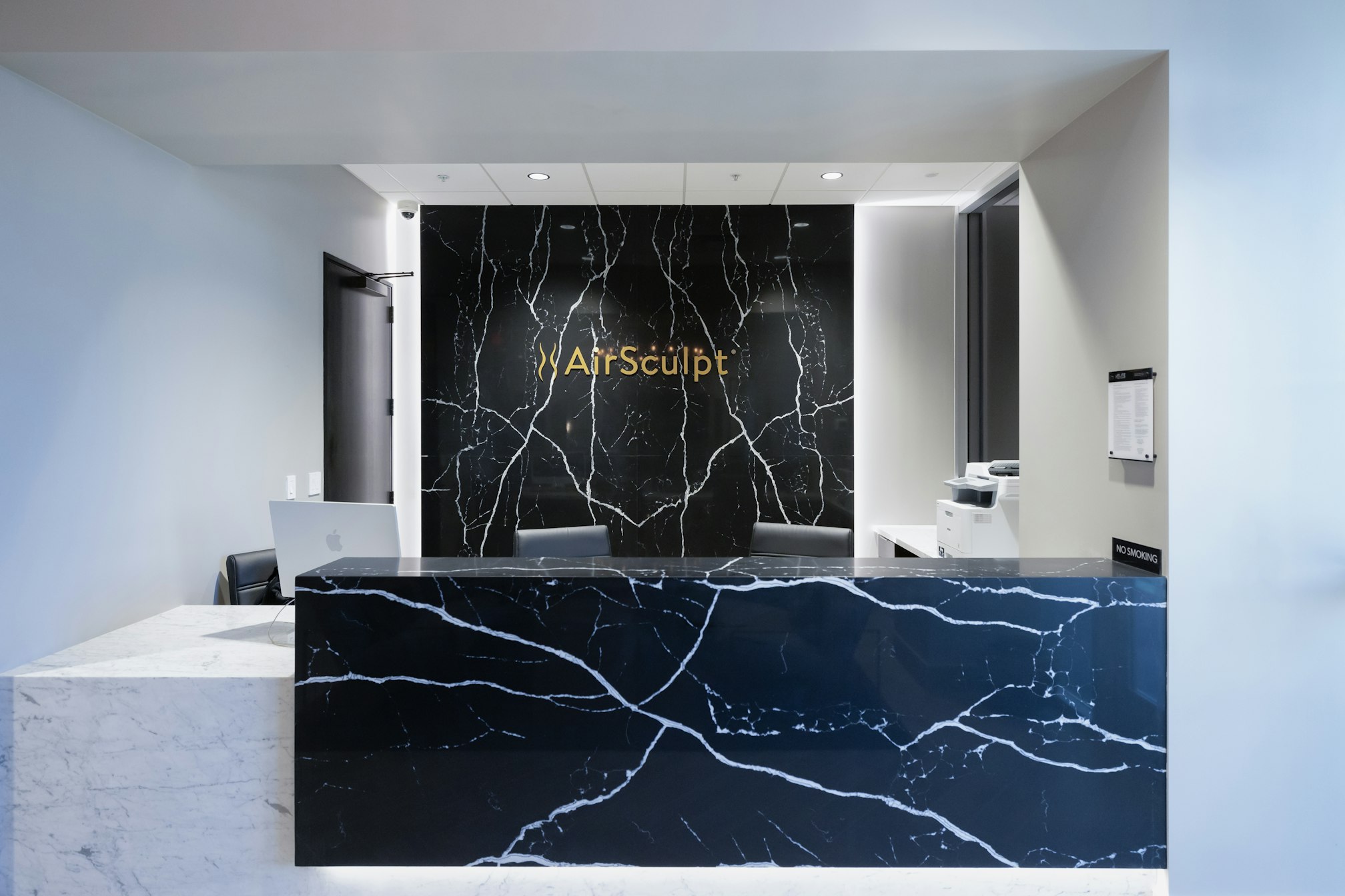 Front desk and backdrop featuring AirSculpt logo in AirSculpt Body Contouring Scottsdale clinic lobby