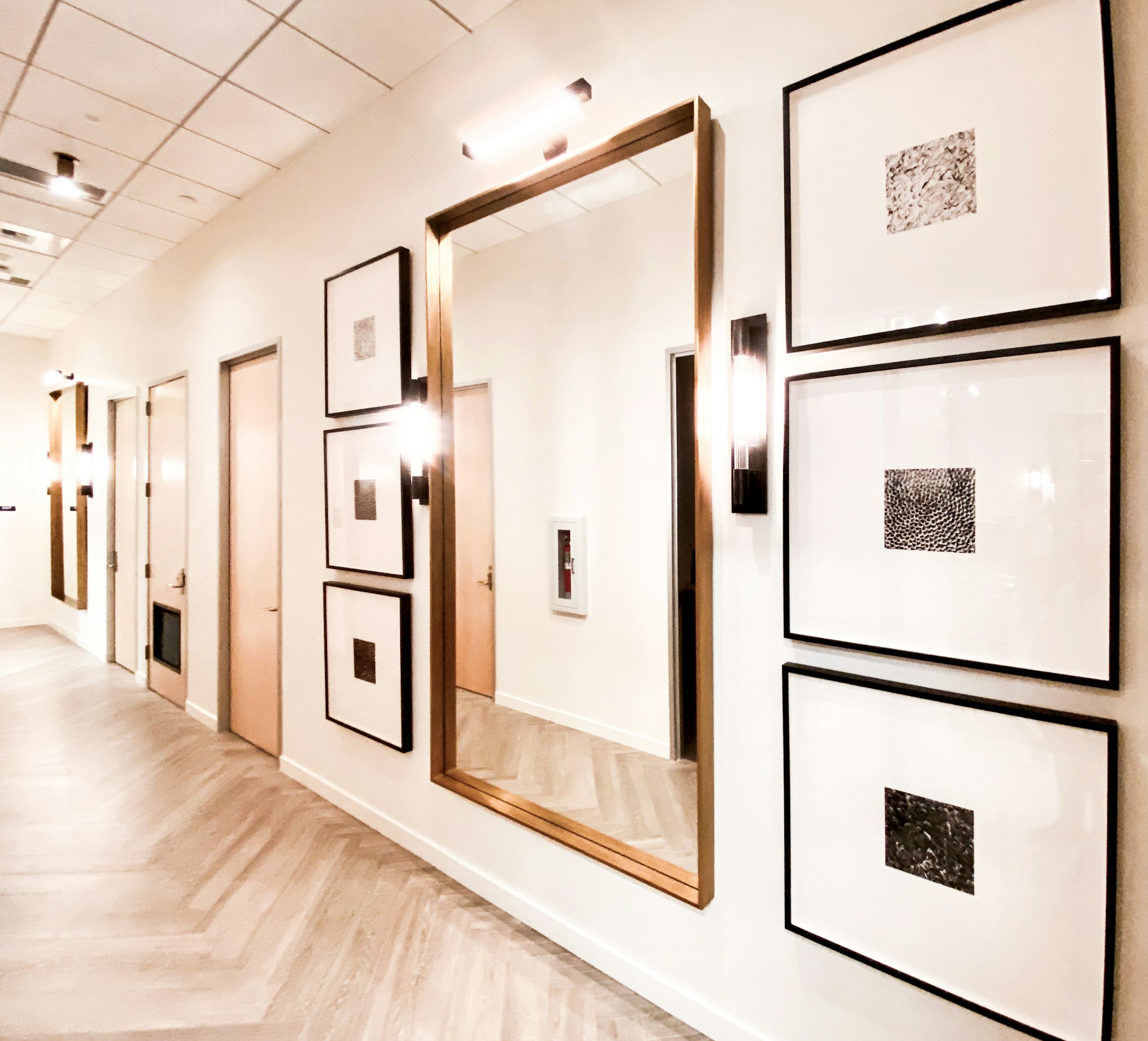 Hallway with framed artwork and wall sconces in AirSculpt Body Contouring Seattle clinic