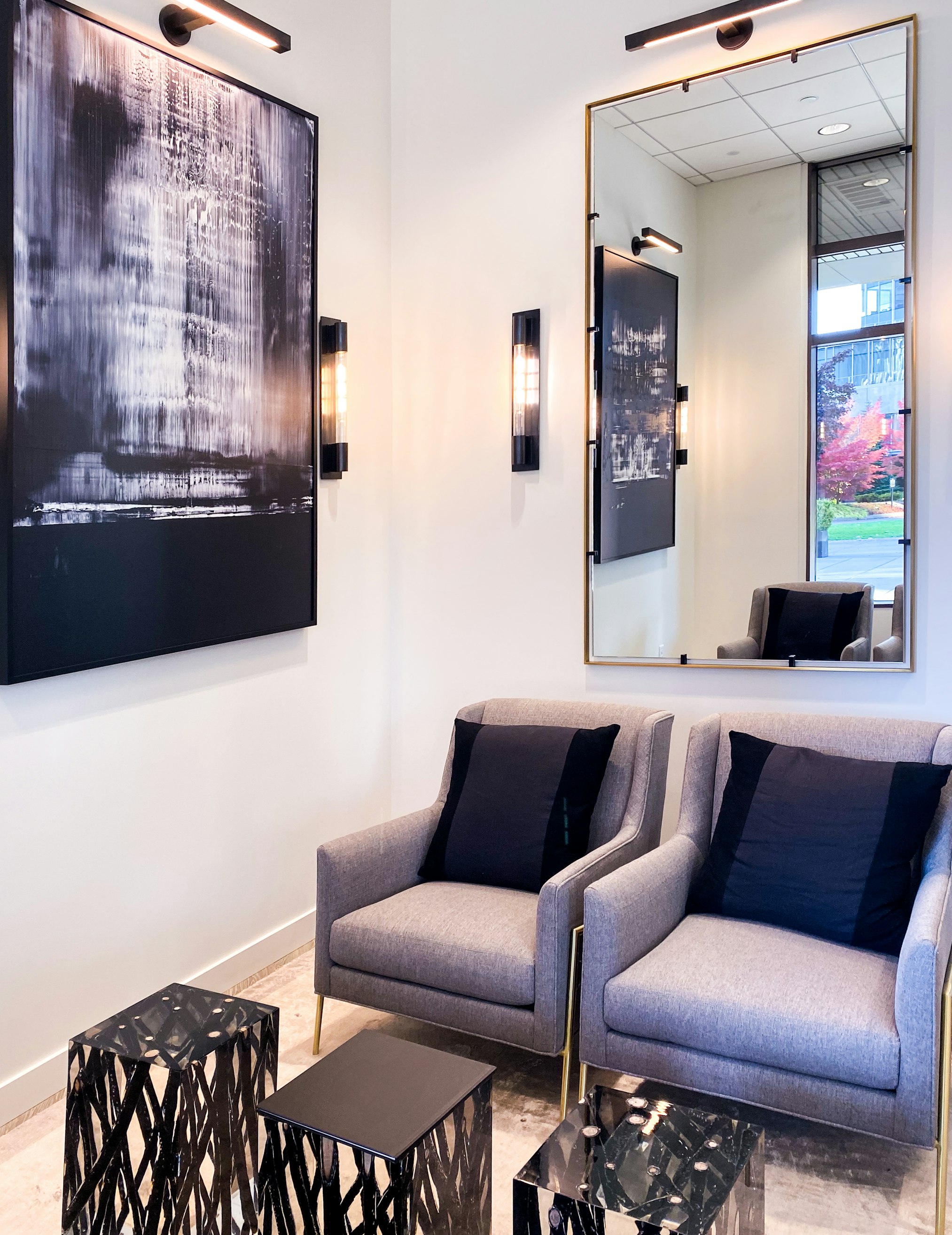 Mirror, wall-mounted artwork, and seating area in AirSculpt Body Contouring Seattle clinic lobby