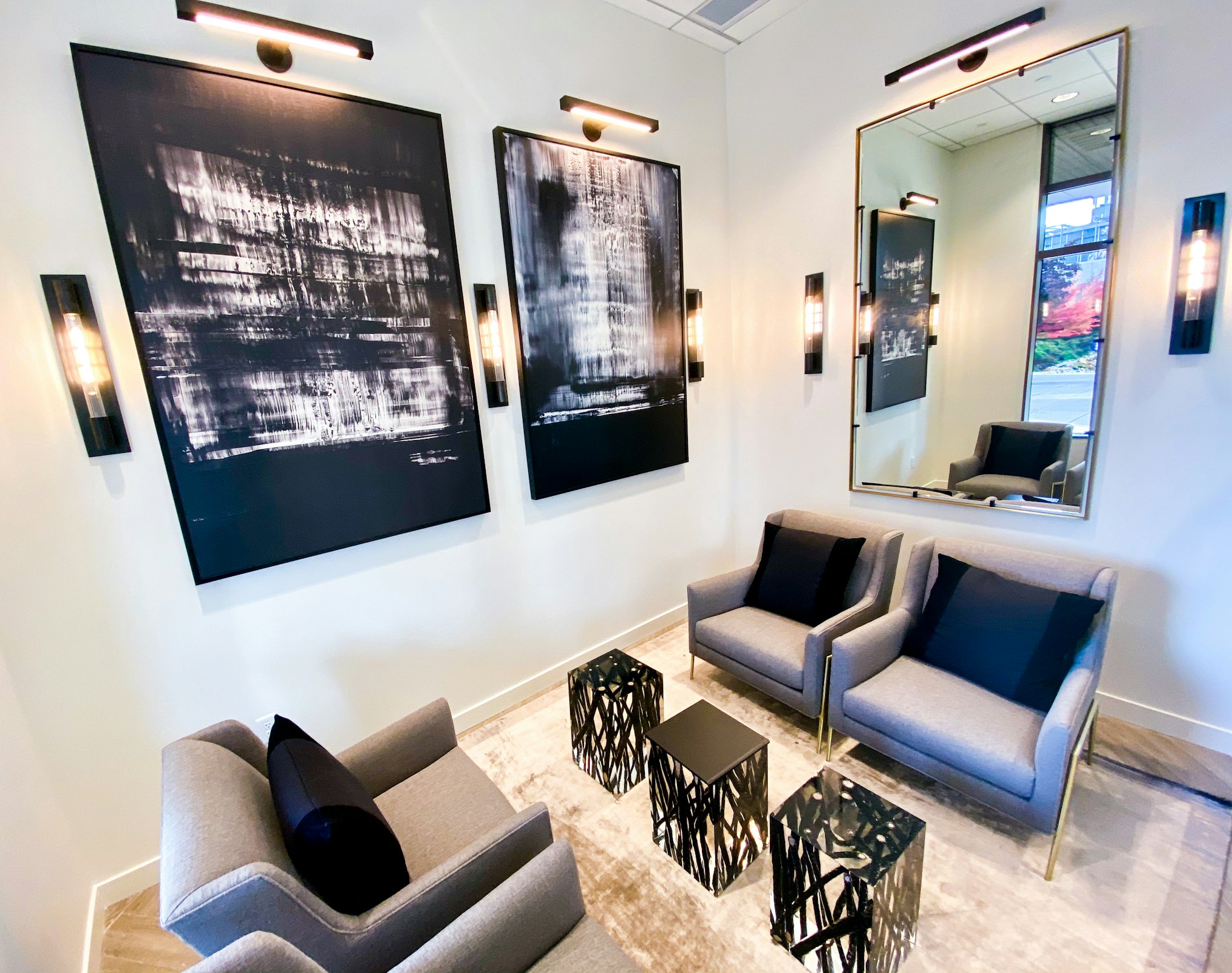 Couch and abstract wall art with lighting fixtures in AirSculpt Body Contouring Seattle clinic lobby