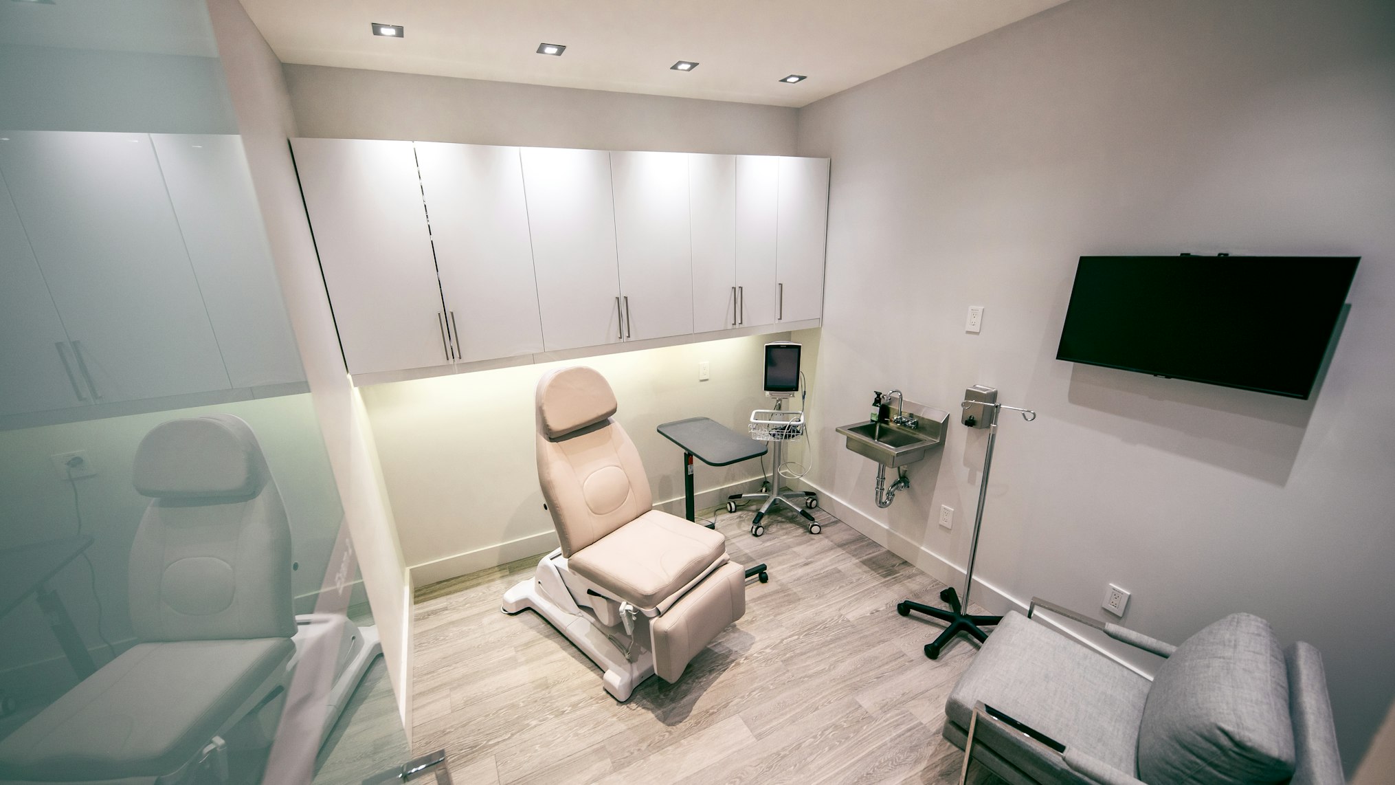 Recovery room with medical chair and cabinetry in Elite Body Sculpture Toronto clinic