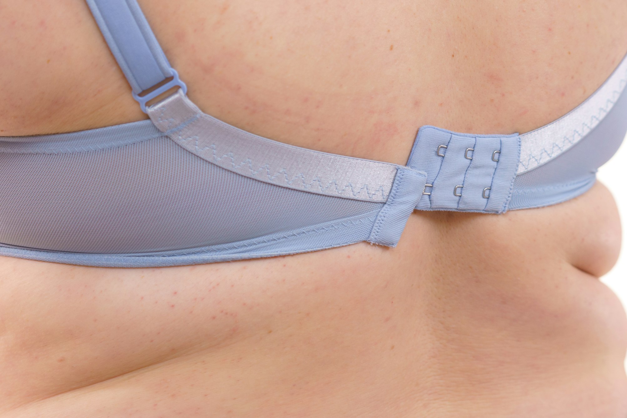Woman wearing bra back view. Clasp band detail.
