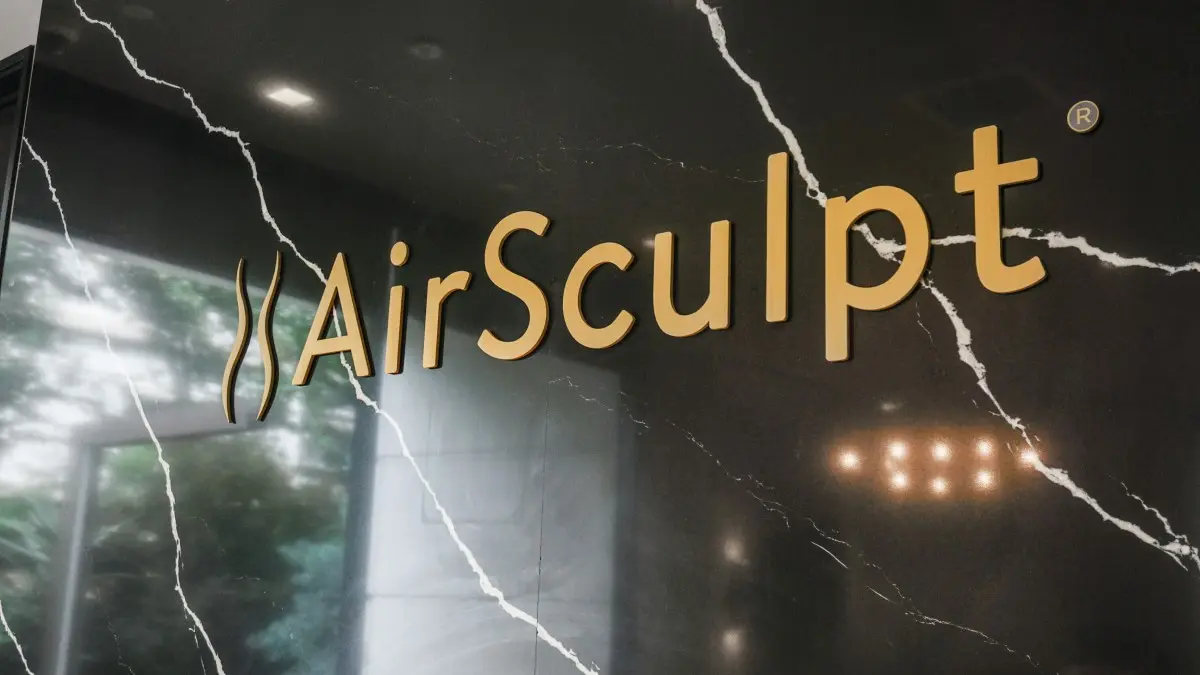 AirSculpt logo displayed on black marble wall in clinic interior