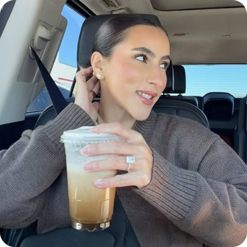woman in car with iced coffee