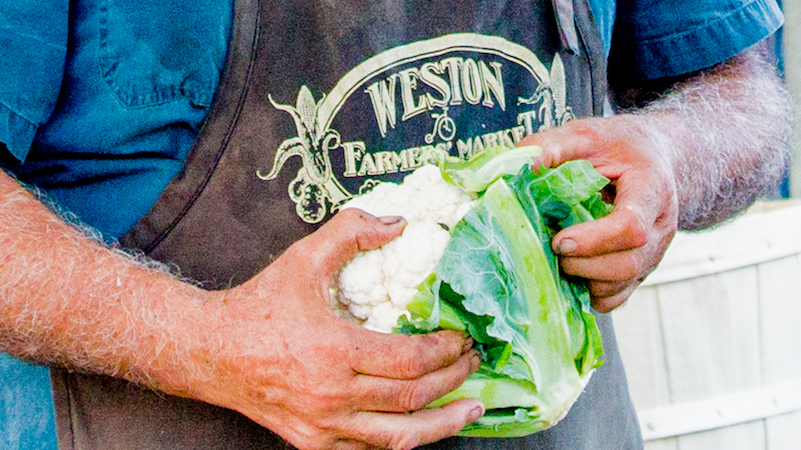 A farmer from Weston Farmer's market holding a cauliflower