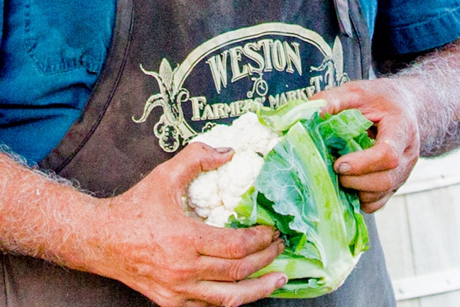 A farmer from Weston Farmer's market holding a cauliflower