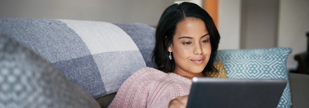 An attractive young woman using a digital tablet at home
