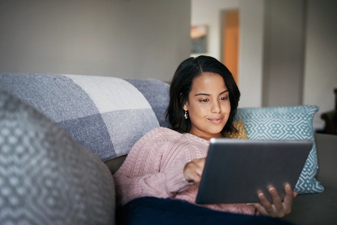 An attractive young woman using a digital tablet at home