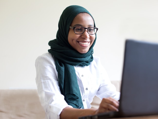 Young muslim woman working on laptop