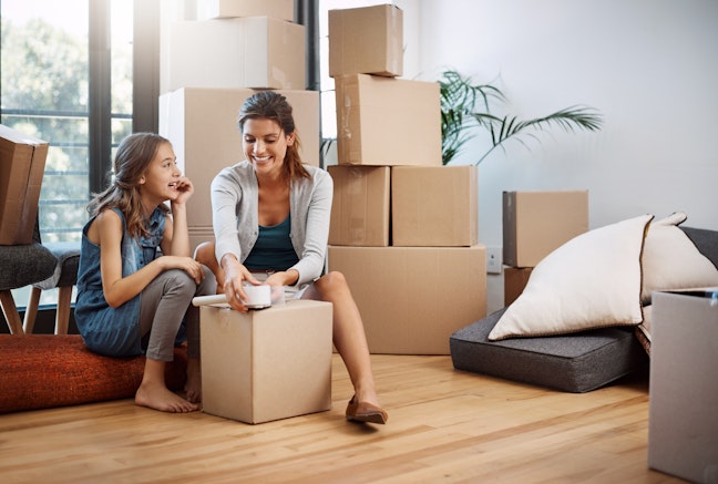 An attractive young woman and her daughter moving into a new house