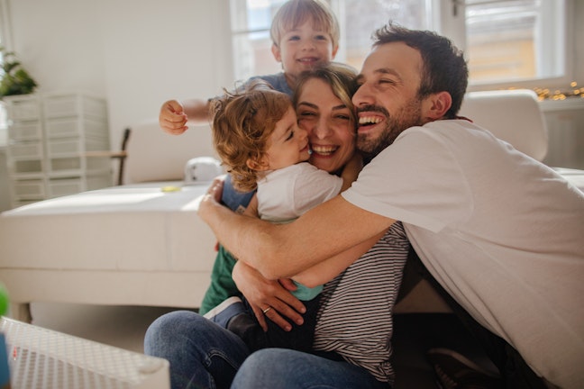 Family hugging in living room