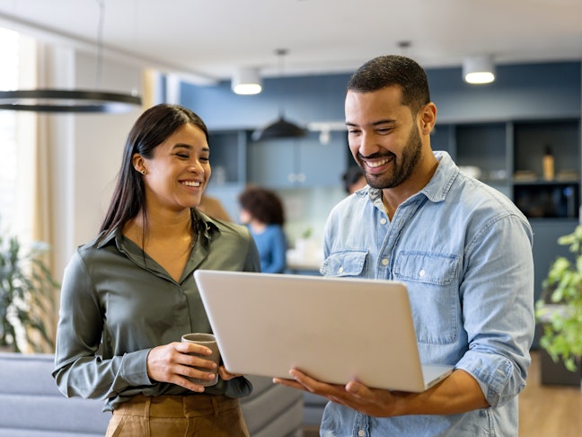 A woman and a man looking at a laptop screen