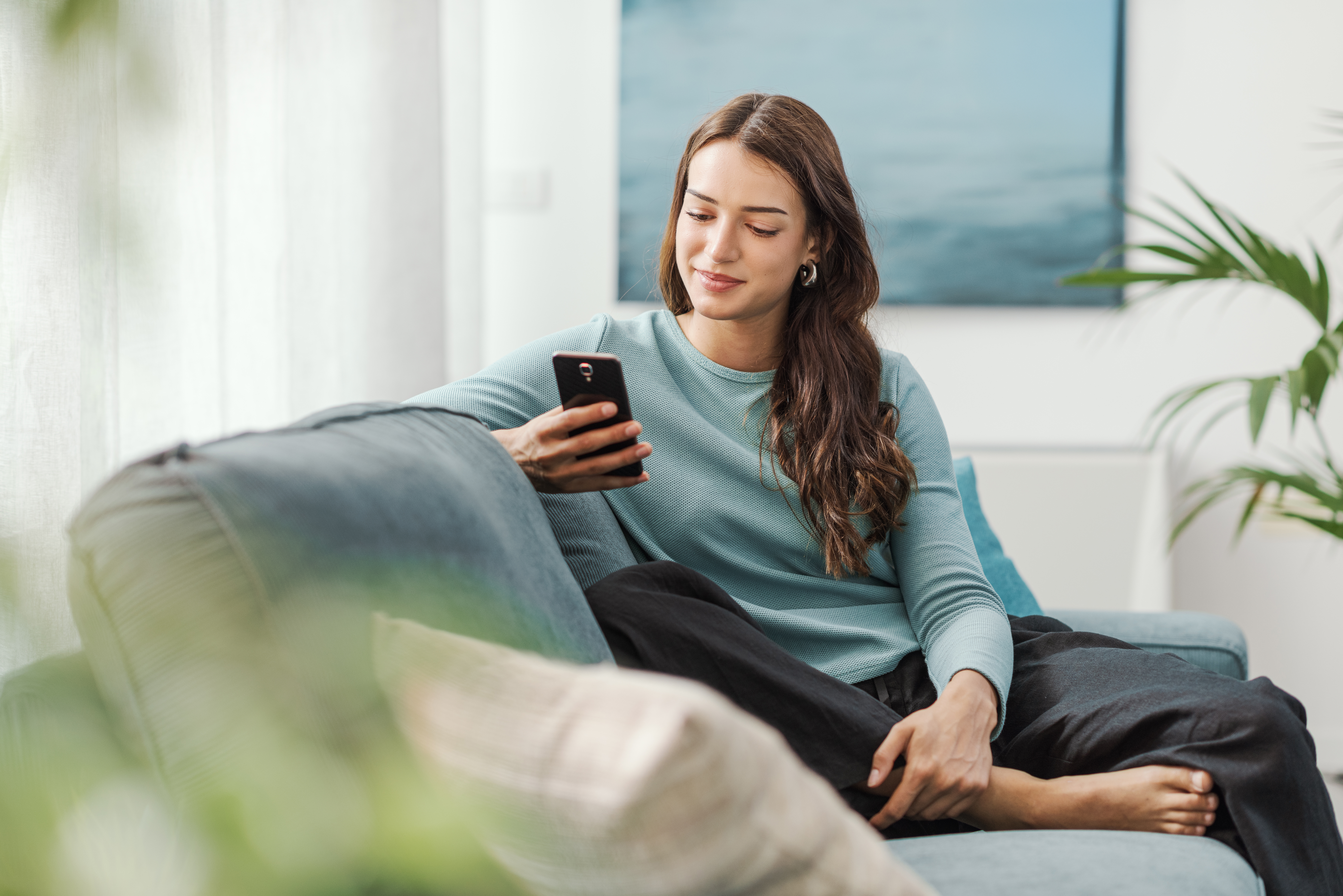 Woman sitting on a sofa looking at her phone