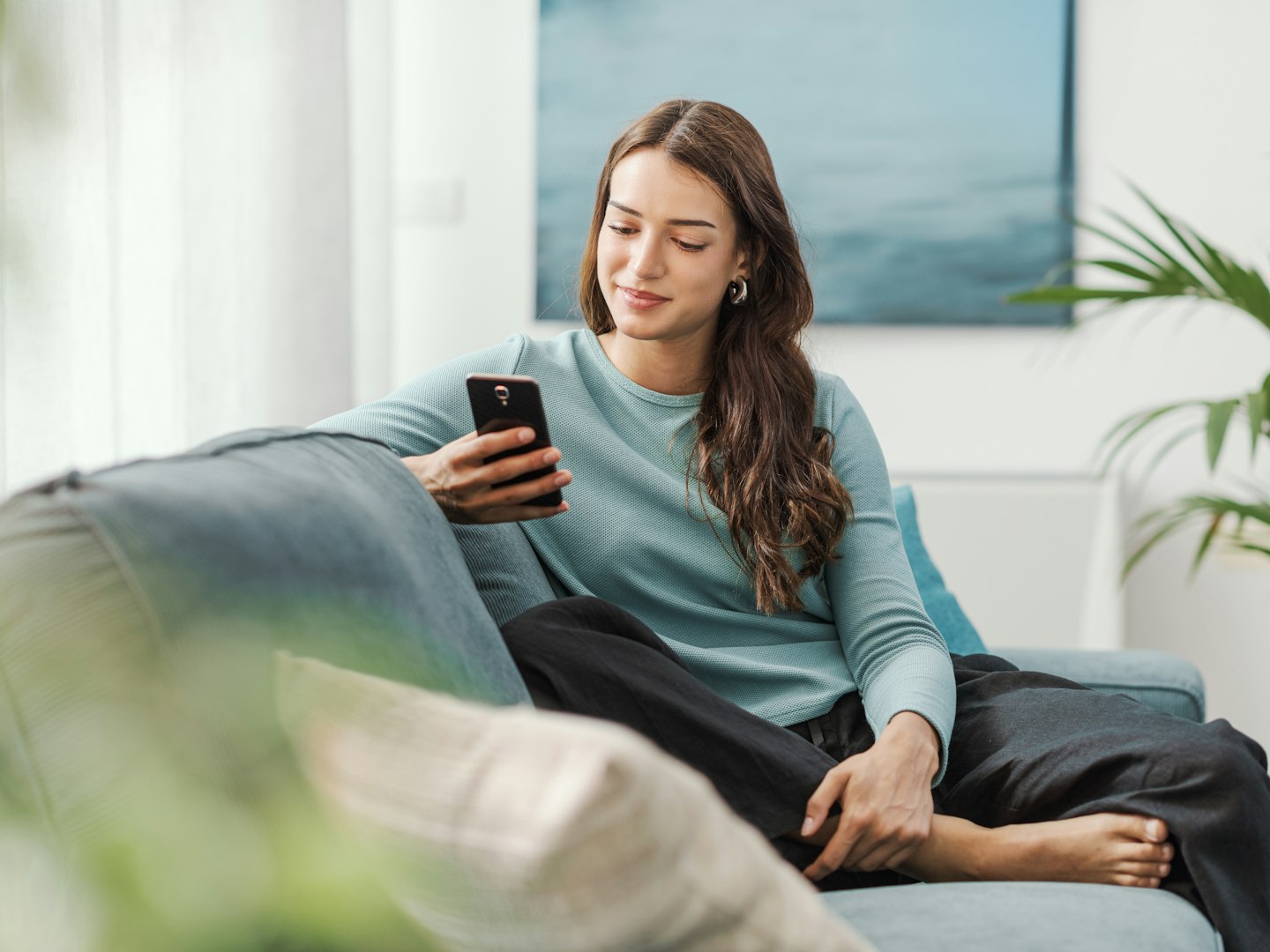 Woman sitting on a sofa looking at her phone