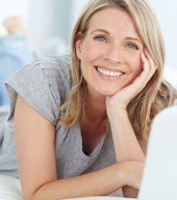 Woman lying on her stomach smiling.