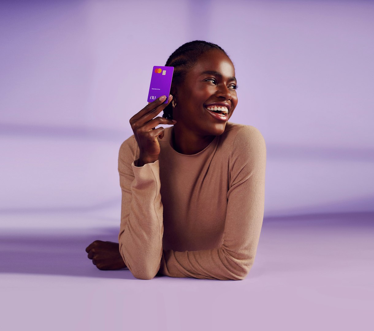 Imagem com uma pessoa segurando o cartão do Nubank