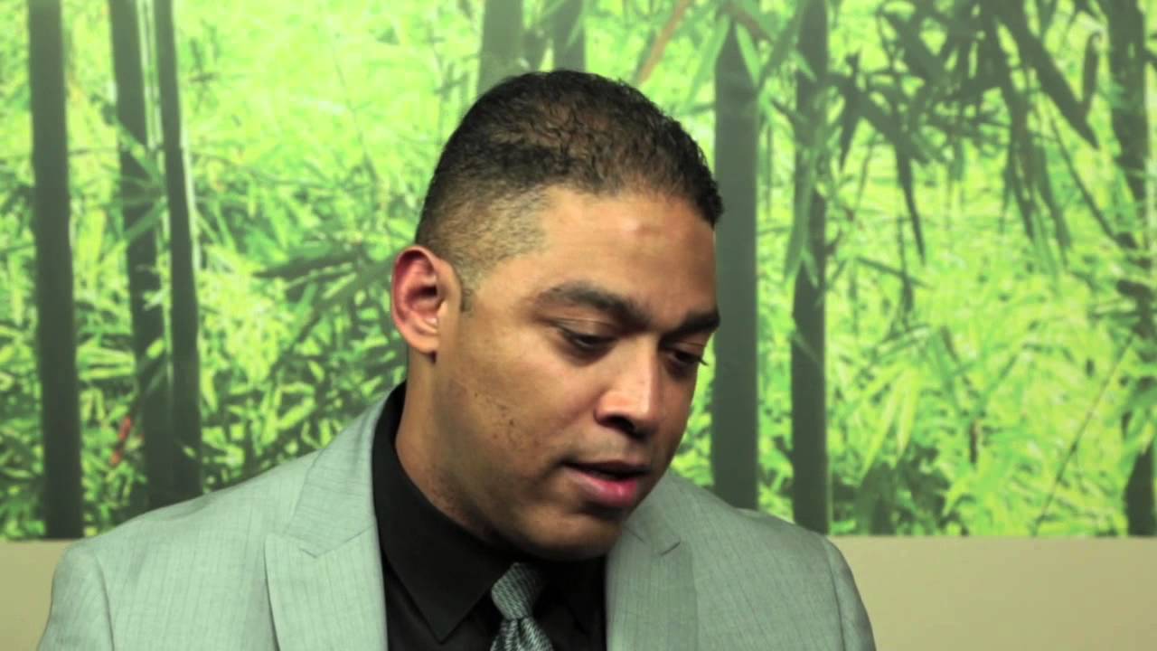 man sitting in front of a green background