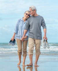 Husband and wife walking on beach