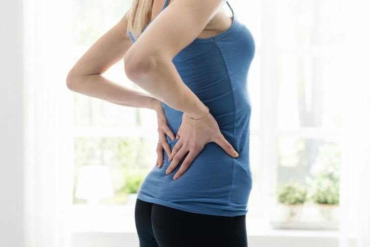 Woman holding her back in pain