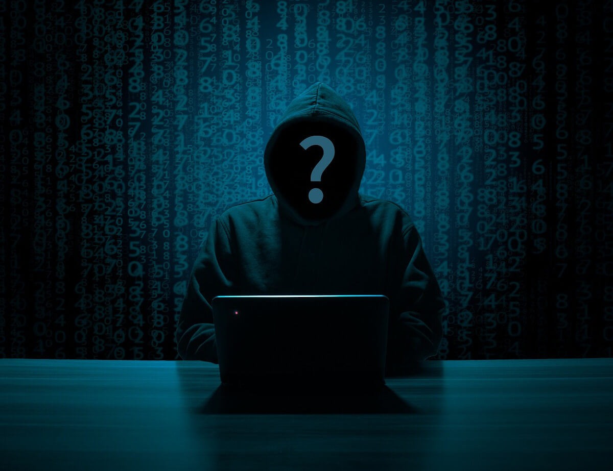 hooded person with question mark over face at computer