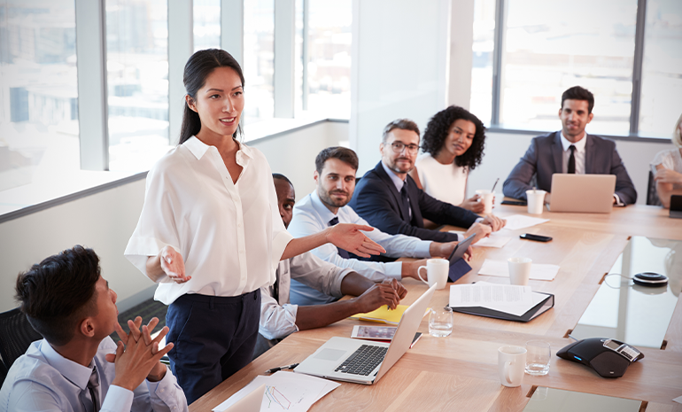 An employee standing up and speaking in the meeting