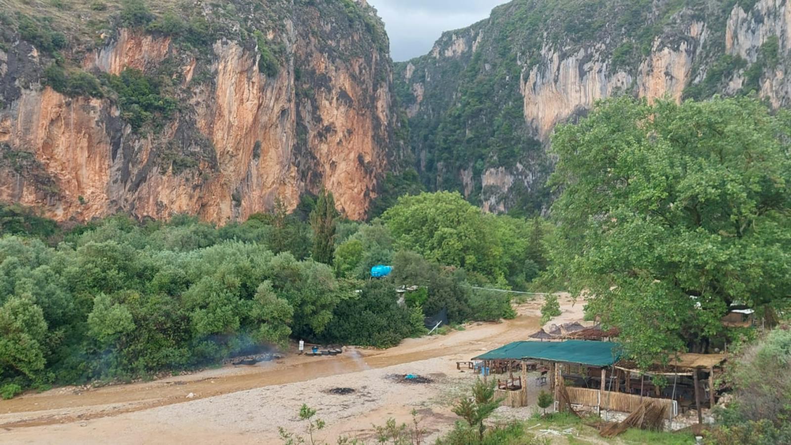 Valley in Albania Picture of a valley in Albania with a river and big mountains surrounding it. There is a small hut right at the river.
