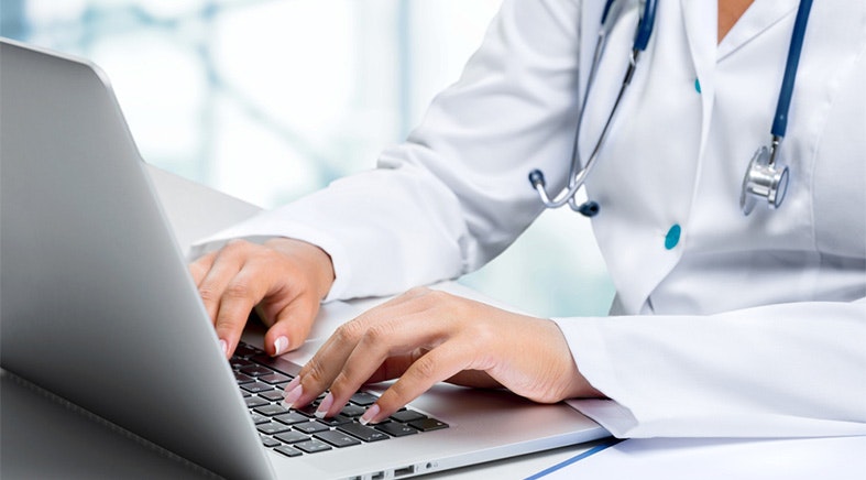medical worker typing on laptop
