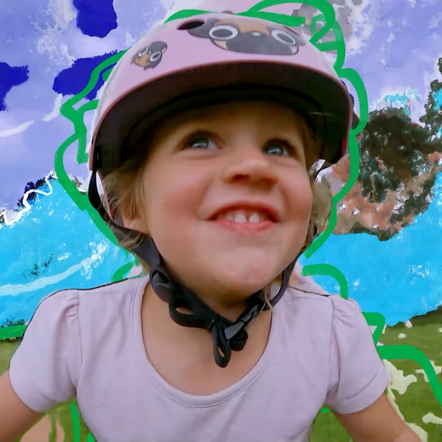 A still from Raleigh Serious Fun of a girl riding a bike. The background has been animated and she wears a pink helmet with pugs on. 