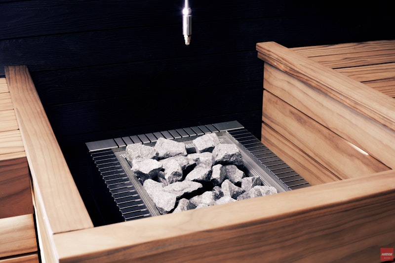 Sauna stones close up with sauna benches showing