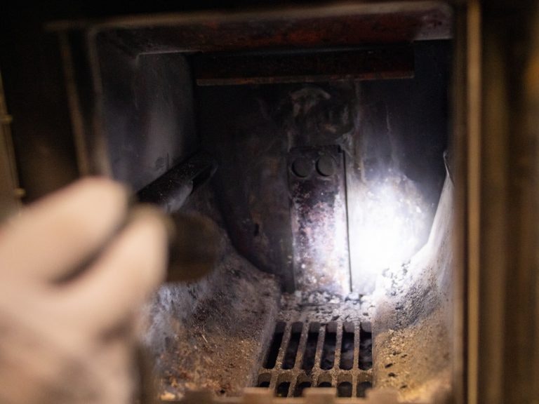 Checking the wood burning sauna heater with a  flashlight