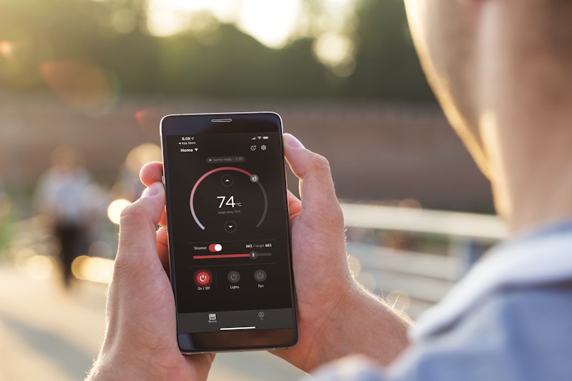 Man with adjusting MyHarvia app while jogging