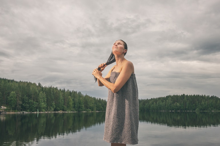 woman drying her hair by the lake