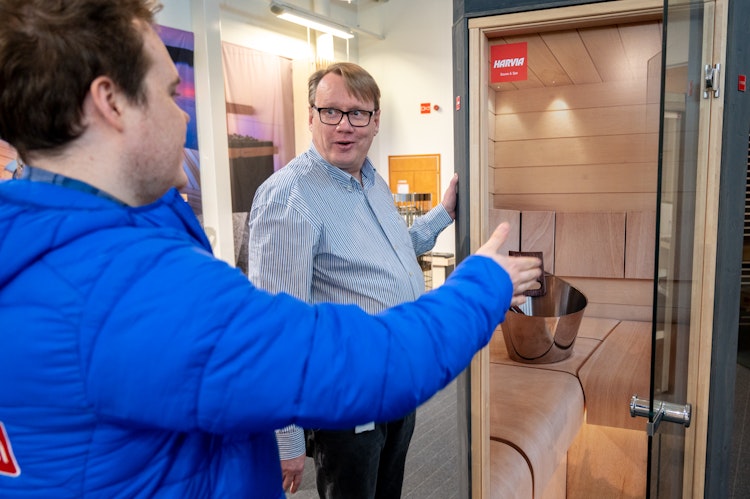 Man showing sauna doors to other man