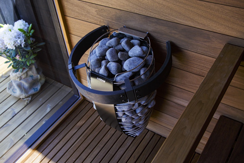 close-up picture of sauna heater in dark colored sauna