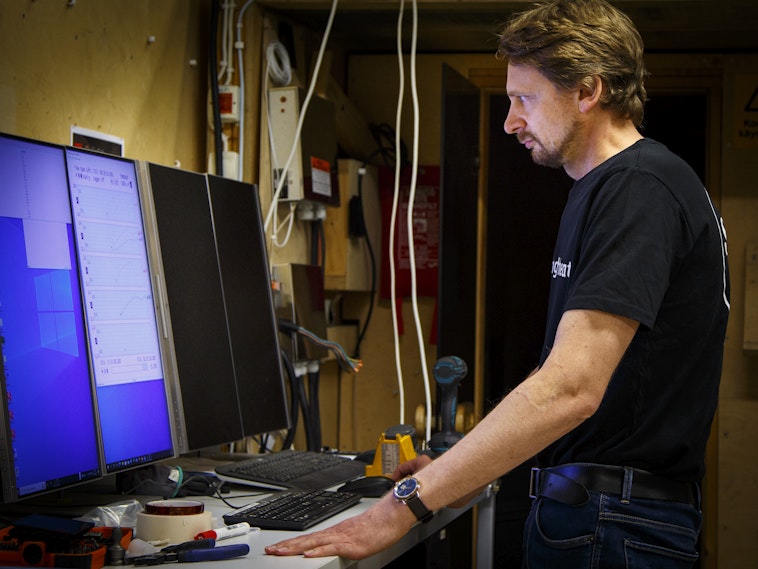 man standing in front of computer checking the computer screen