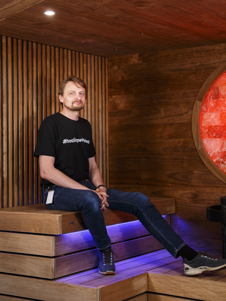 man sitting in dark colored sauna