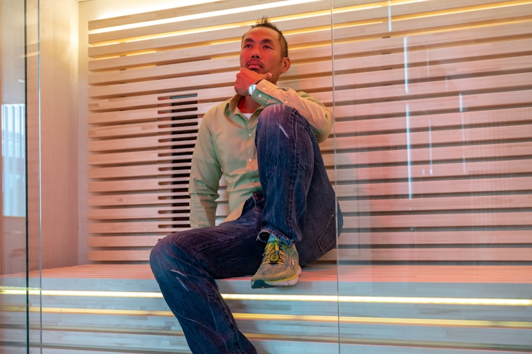 man sitting inside light colored sauna