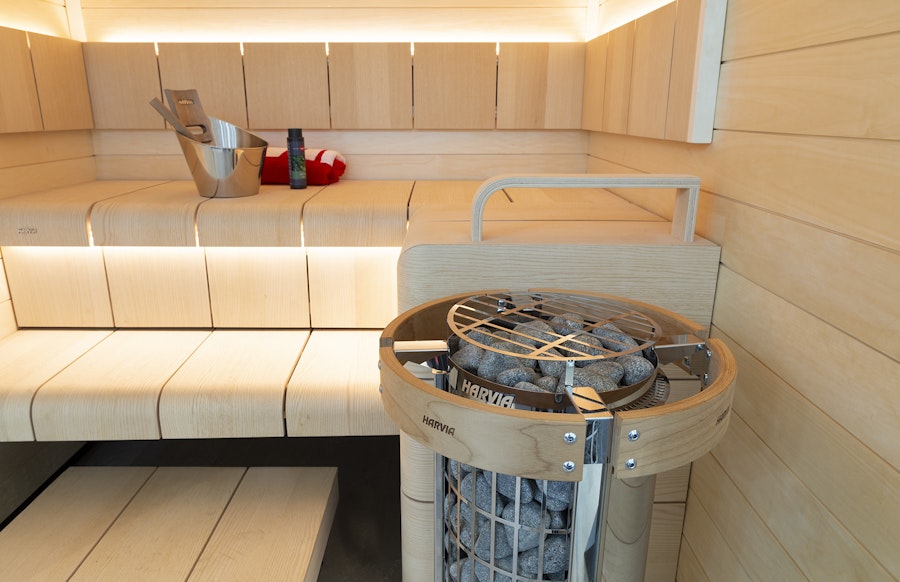 Harvia Cilindro heater with safety railing installed in a sauna room showing proper clearance and placement