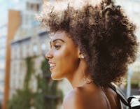 Beautiful woman with curly hair, smiling outside