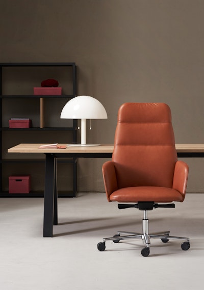 Hanami armchair with rotating synchronized system Hanami swivel armchair behind a desk and a shelf