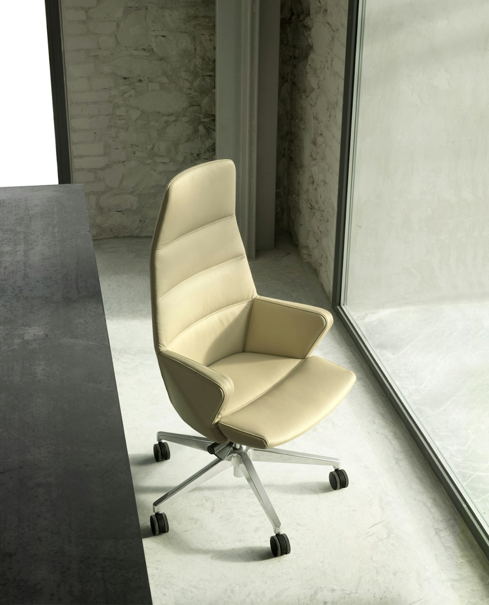 Seduta direzionale da scrivania Hyway Poltrona beige Hyway collocata vicino ad una scrivania rivolta verso la luce