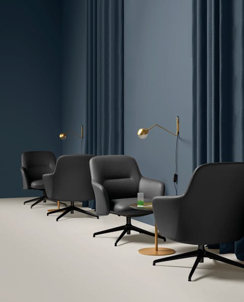 Level lounge armchair has generous shapes Level armchairs arranged like a mirror near a coffee table in the center
