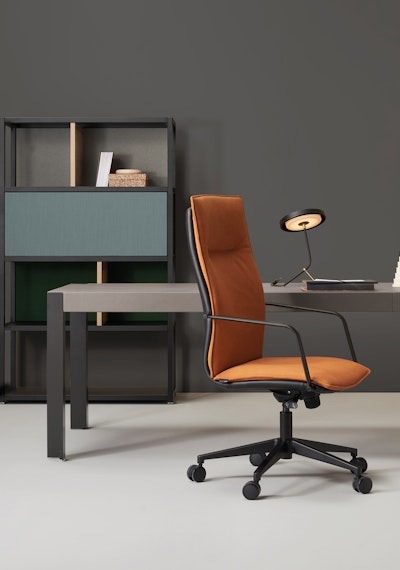 The Armchair Maybe is the reference model of the collection Maybe armchair in orange fabric in a hypothetical office