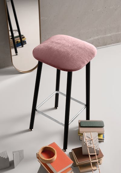 Bista stool in front of a mirror with room accessories