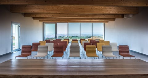 Sedute Quinti di colore differente disposte in fila in una sala conferenze